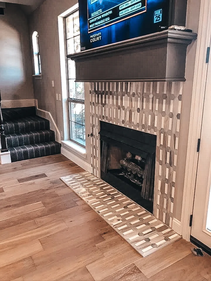Geometric patterned tile fireplace surround with linear hearth tile installation