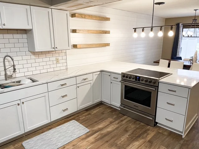 White kitchen with subway tile backsplash, stainless steel range, and wood shelving